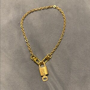 Authentic Louis Vuitton lock with gold toned necklace